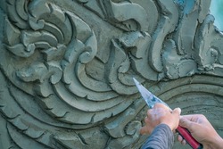 sculptor working - Low relief cement thai style handcraft of thai temple for background and design.