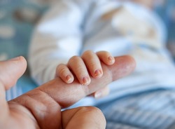 Detail of the fingers of a newborn, especially the nails. Newborn babies have long, sharp nails full of nerve endings.