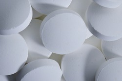 White round pills macro shot. Medical full frame background. Backdrop pile of round pills or tablets, antidepressants or painkillers close up.