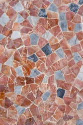 Geometric mosaic texture with multi-colored tiles on floor made of red marble. Traditional mosaic pattern design in vintage tone as background upper closeup