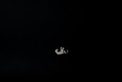 toy astronaut falling into the void in the middle of the black space background