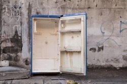 Old and grunge of crack or waste used refrigerator left on the street