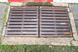 Old iron grates with rust through a long time. Used to drain concrete surface to prevent water outflow and prevent flooding within residential areas.