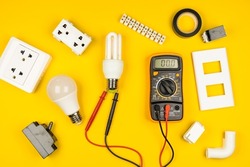 Different electrician's supplies on yellow background. Background of professional electrician tools with space for text.electrician concept home electrical repair technician.