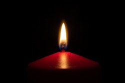 Closeup red candle flame isolated with black background