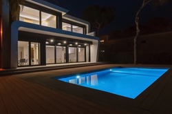 Modern villa with pool at night. Home real estate Luxury exterior with led lights. Nobody inside.