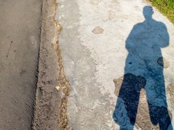 simple background of a human shadow standing in front of the road