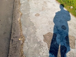 simple background of a human shadow standing on the side of the road