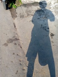simple abstract background of a human shadow standing on the side of the road