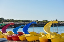Paddle boats or pedalo lined up by the sea at the beach