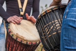 People hands playing music at djembe drums