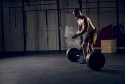 Athlete motivates screaming before barbells exercise at gym