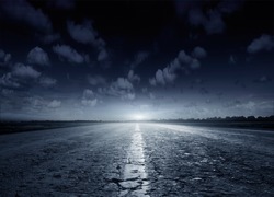 Night road against the background of cumulus clouds