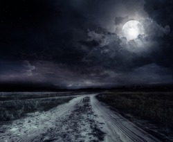 country road at night with large moon