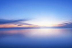 Calm blue colored sea and clear sky at sunset. Extreme long exposure, horizontal view