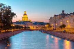 Night view on illuminated Moyka River and Saint Isaac's Cathedral behind buildings, St. Petersburg, Russia