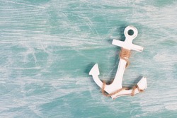 White anchor on a blue textured background, maritime sea life, sailing trip, summer vacation, tourism concept, harbor