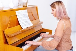 The piano teacher experienced pianist preparing to lesson. Creative hobby and activity. Beautiful woman composer write romantic song, playing piano. Musical artist create instrumental acoustic melody.