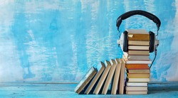 audio book concept with stacks of books and vintage headphones,literature,entertainment,education, good copy space