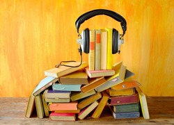 audio book concept, with stack of books and vintage headphones. Podcasting,education,digital book concept.