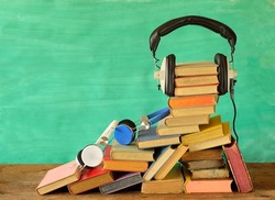 audio book concept, with stack of books, various headphones, literature,podcasting,entertainment,education concept, good copy space