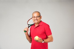 Senior indian/asian healthy sportsman playing individual sport, isolated on plain background