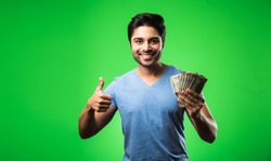 Indian happy man with money fan, standing isolated against green chroma screen