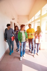 Cheerful Indian asian young group of college students or friends walking in campus corridor or on stairs