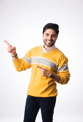 Indian handsome man wears winter wear or woolen sweater, presenting or showing. Standing against white background