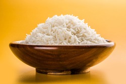 cooked plain white basmati rice served in a wooden bowl, isolated over colourful or wooden background