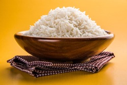 cooked plain white basmati rice served in a wooden bowl, isolated over colourful or wooden background