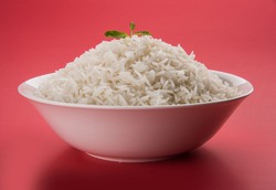 cooked plain white basmati rice served in a ceramic bowl or plate, isolated over colourful or wooden background