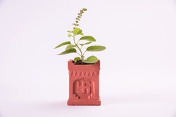 Indian traditional Pot or special masonry structure known as Tulsi Vrindavan or Vrundavan with swastik and aum writting, holy hindu object, isolated, selective focus