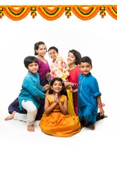 Group of Indian Kids holding Ganpati Idol on Ganesh festival or Chaturthi, welcoming god. Standing isolated over white background