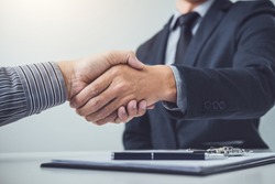 Handshake of cooperation customer and salesman after agreement, successful car loan contract buying or selling new vehicle.