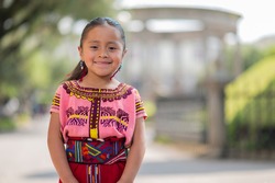Portrait of a beautiful indigenous girl with a colorful dress from Quiche.