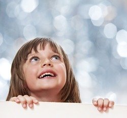 little girl with  white board with empty space - bokeh background