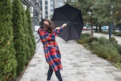 Young woman fighting a storm with her umbrella
