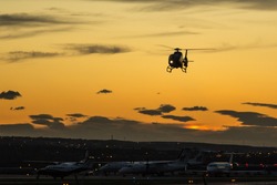 A helicopter coming in to land at sunset