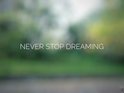 Motivational and inspirational quote ; Never stop dreaming ; with blurred and abstract background 