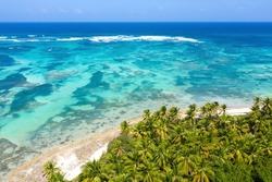 Bounty and pristine tropical shore with coconut palm trees and turquoise caribbean sea. Beautiful landscape. Aerial view from drone