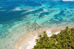 Bounty and pristine tropical shore with coconut palm trees and turquoise caribbean sea. Beautiful landscape. Aerial view from drone