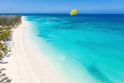 Bounty and pristine sandy shore with coconut palm trees, caribbean sea washes tropical coastline. Arenda Gorda beach. Dominican Republic. Aerial view