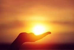Sun on female hand. Silhouette of hand holding sun
