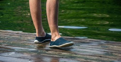 Closeup detail of the feet of a man wearing neoprene water shoes . Water shoes , swimming shoe