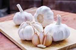 Big garlics cloves on wooden plate