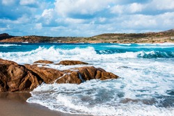 a view of the rock formations and the Mediterranean sea, with a strong swell, in La Marinedda beach, in Isola Rossa, Sardinia, Italy