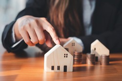 house model ,The hand of the businessman guarding close Money saving ideas to buy a home or loan for real estate investment planning and ideas during saving can be risky.