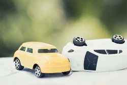 Vehicle insurance car accident concept : Two Miniature cars accidents crash on road, broken toys auto car on city map, green background.