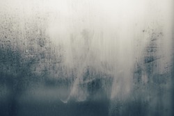 Vintage tone image of rain drop on foggy glass. Blurred grunge abstract overlay texture background with gradient colors. 